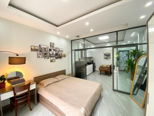 a bedroom with a bed and a table and a desk at Calmette Home in Ho Chi Minh City
