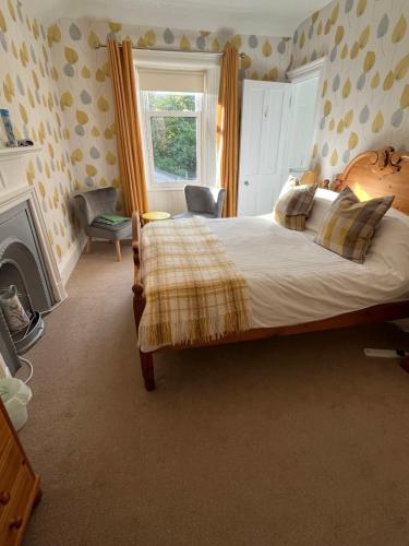 um quarto com uma cama grande e uma lareira em Conval House Bed And Breakfast em Dufftown