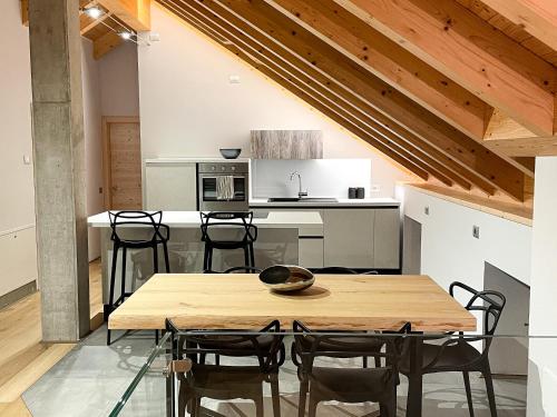 uma cozinha e sala de jantar com uma mesa de madeira e cadeiras em Appartamento Moderno ed Esclusivo - Casa Pierina em Lastebasse