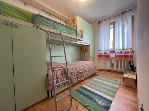 ein Schlafzimmer mit Etagenbetten und einer Leiter in der Unterkunft 094 Trilocale, pinzolo in Pinzolo