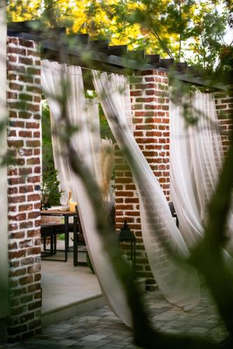 an archway with white curtains in a patio at House "Mediterrian spirit" with jacuzzi in Zadar in Zadar