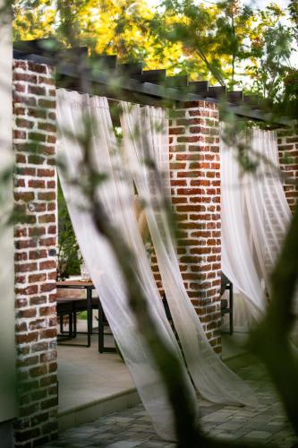 a set of white curtains on a patio with a table at House "Mediterrian spirit" with jacuzzi in Zadar in Zadar