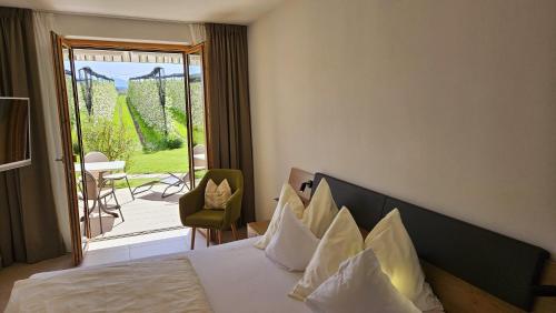 Cette chambre d'hôtel comprend un lit et un balcon. dans l'établissement Appartements Weisshauserhof, à Appiano sulla Strada del Vino