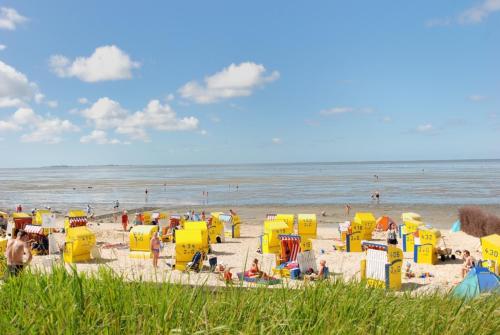 a beach with a bunch of colorful beach huts at Ferienpark Harmsen in Cuxhaven