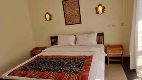 een slaapkamer met een bed met een tapijt erop bij Phasouk Viengmai Villa in Luang Prabang