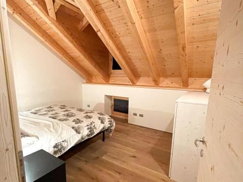um quarto com uma cama e um tecto de madeira em Appartamento Moderno ed Esclusivo - Casa Pierina em Lastebasse