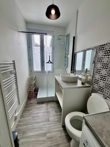 une salle de bain blanche avec un lavabo et des toilettes dans l'établissement Le “Chez-nous” - Maison atypique de 90m2, à Dieppe
