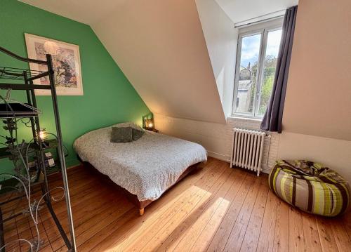 a bedroom with a bed and a green wall at Le “Chez-nous” - Maison atypique de 90m2 in Dieppe