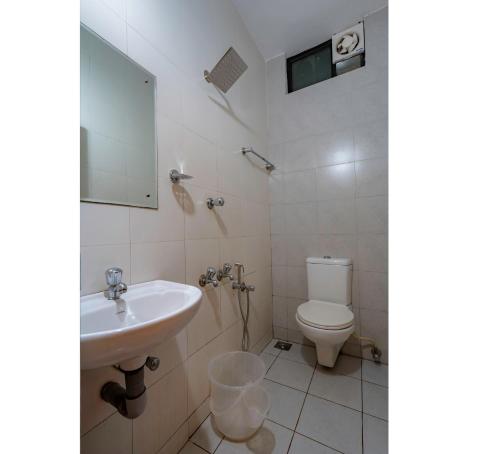 a bathroom with a sink and a toilet at Prime Palace Hotel - MG Road in Cochin