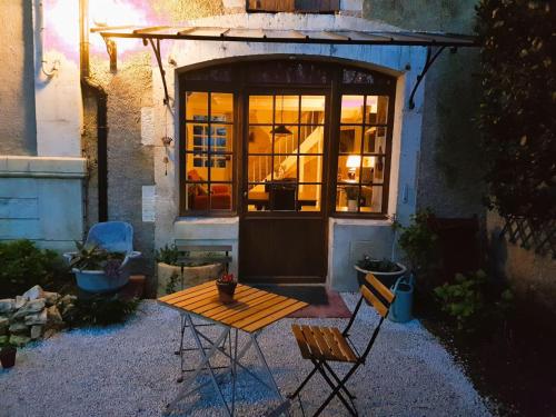 un patio avec une table et des chaises devant un bâtiment dans l'établissement Maison Chinsa, à Saint-Angeau