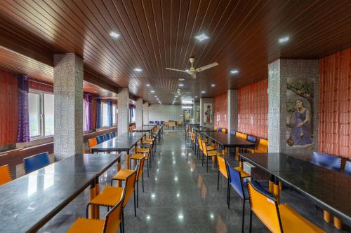 a row of tables and chairs in a cafeteria at Sri Nandha Luxury Comforts in Vālpārai