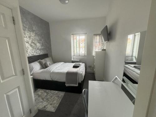um pequeno quarto com uma cama num quarto em Copperfield Homestay em Cardiff