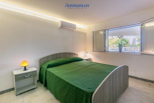 - une chambre avec un lit vert et une fenêtre dans l'établissement House&Villas - Villa le Palme di Vendicari - Garden View, à Reitani