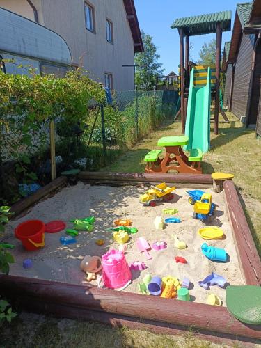 a sandbox with toys in the sand in a backyard at Domki BIAŁA MEWA in Wicie