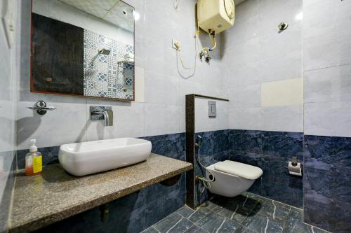 a bathroom with a sink and a toilet at Belwood Inn Hotel Near Delhi Airport in New Delhi