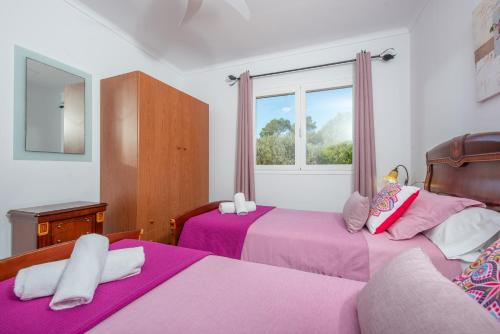 a bedroom with two beds and a window at Vista Sol in Ariany