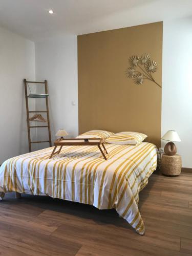 a bedroom with a bed with a yellow and white striped blanket at La Suite en Or in Saint-Dizier