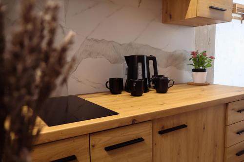 a kitchen counter with three coffee cups on it at Seaside Apartments Roja in Roja
