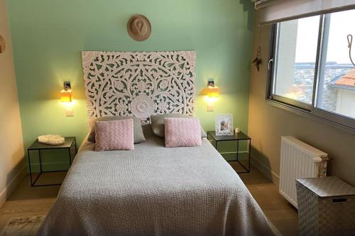 une chambre avec un grand lit avec des oreillers roses dans l'établissement Maison de 250 m2 avec SPA à Arcachon, à Arcachon