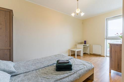 a bedroom with a bed and a window at Apartament Fregata in Gdańsk
