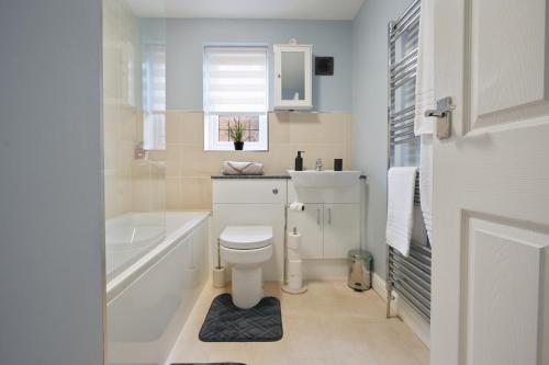 a white bathroom with a toilet and a sink at Cosyhome ideal for professionals in Barrow upon Humber