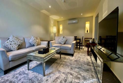 un soggiorno con divano e tavolo di Royal L'azure Resort a Sharma