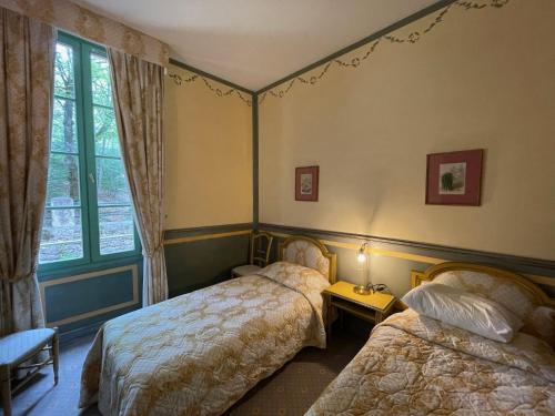 1 dormitorio con 2 camas y ventana en le 24 du château en Montbrun-les-Bains