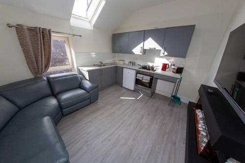 a living room with a couch and a kitchen at Unit 3 Modern Self Contained Apartment in Cobh