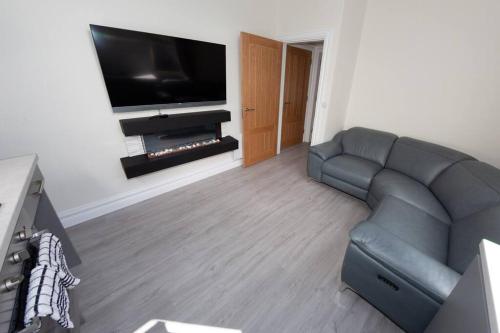 a living room with a couch and a flat screen tv at Unit 3 Modern Self Contained Apartment in Cobh