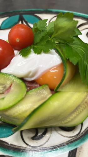 a plate of vegetables with tomatoes and lettuce at Casa Oliva borgo del Benessere Olistico in Bargni