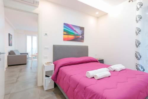 una camera da letto con un letto rosa con una coperta rosa di Mascarella Apartments a Bologna