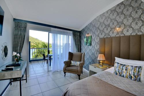 a bedroom with a bed and a desk and a chair at The Shore House in Hartbeespoort