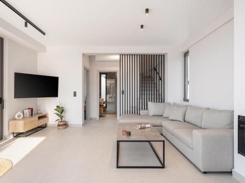a living room with a couch and a table at Villa Zefyros With Sea View in Plataniás