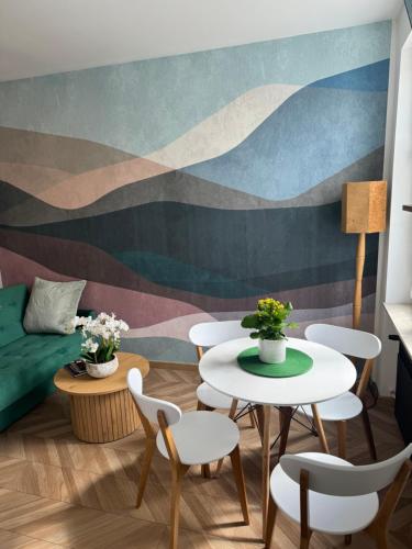 a living room with tables and chairs and a mural at Ogarna 33 studios in Gdańsk