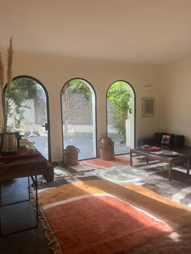 a living room with three arched windows and a table at MORO Marrakech Boutique Hôtel in Marrakech