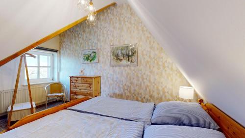 a bedroom with a bed and a dresser and a window at Ferienhaus Fischerhaus in Seedorf