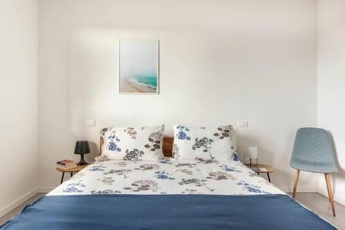um quarto com uma cama e uma cadeira azul em casa MEV è un attico in centro a Fiume Veneto em Fiume Vêneto