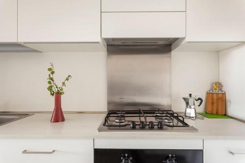a kitchen with white cabinets and a stove top oven at casa MEV è un attico in centro a Fiume Veneto in Fiume Veneto