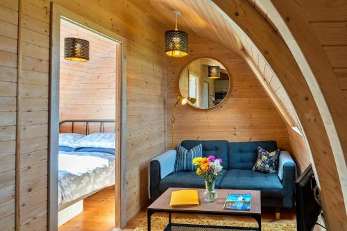 Pokój z niebieską kanapą i łóżkiem w obiekcie Finest Retreats - The Pods w mieście Camerton