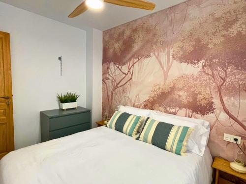 1 dormitorio con 1 cama con un mural en la pared en Home4u Increíble piso centro Granada en Granada
