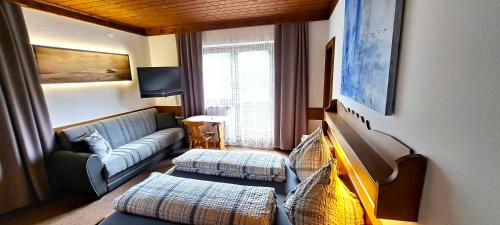 a living room with a couch and two ottoman at Appartements Moser in Viehhofen