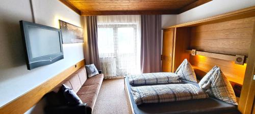 a living room with a couch and a flat screen tv at Appartements Moser in Viehhofen
