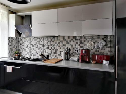 a kitchen with white cabinets and a counter top at Apartament ASR in Piatra Neamţ