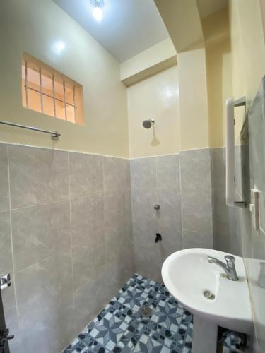 uma casa de banho com um lavatório e um chuveiro em SHELVES SIARGAO em General Luna