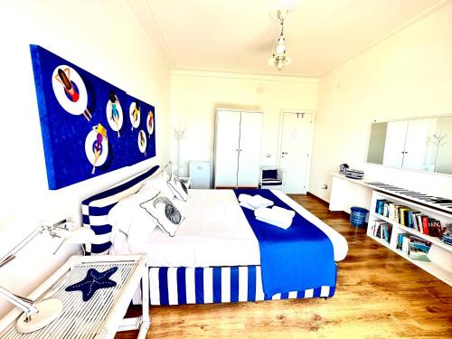 a bedroom with a blue and white bed and a desk at Il Profumo del Mare GuestHouse in Cagliari