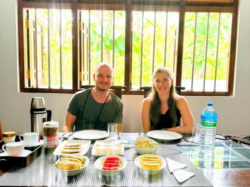 a man and woman sitting at a table with food at Residence Inn in Udawalawe