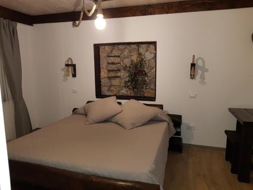 um quarto com uma cama com um quadro na parede em B&B MON AMOUR 