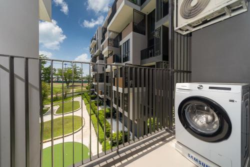 uma máquina de lavar roupa na varanda de um edifício em Laguna BangTao Beach skypark Apartment em Phuket