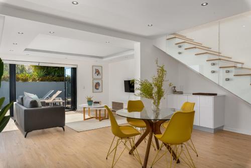 un soggiorno con tavolo e sedie gialle di Kloof Road Luxury Apartments a Città del Capo