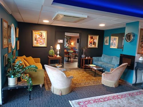 salon z niebieską kanapą i krzesłami w obiekcie Hôtel Kyriad Brive Ouest w mieście Brive-la-Gaillarde